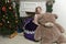 Girl in purple dress at christmas with a huge bear