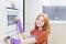 Girl in purple gloves sponges oven in  modern kitchen