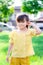 Girl pushed her ears with white grass flowers and have sweet smile. Children stand on the green lawn in summer or spring.