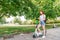 Girl pushes off ground to start riding scooter