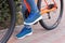 The girl put her foot on the bicycle pedal. A bicycle element on a street background.