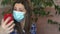 Girl puts on a medical mask on her face and takes a selfie photo