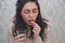 The girl puts a pill on her tongue and prepares to drink water