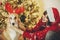 girl putting on cute dog reindeer antlers on background of golden beautiful christmas tree with lights in festive room. doggy wit