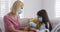 Girl putting face mask on her teddy bear toy at home