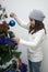 Girl putting ornament on Christmas tree