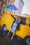 Girl raised her bright colored umbrella like Mary Poppins and smiling against the background of yellow van