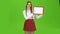 Girl raises a red tablet with paper. Green screen