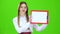Girl raises a red tablet with paper . Green screen