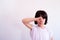 girl raising her hand to wipe her face Covering his face in a white shirt on the cliff.