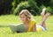 Girl reading the book. Blonde beautiful young woman with book lying on the grass. Outdoor. Sunny day