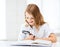 Girl reading book with magnifier at school