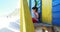 Girl reading book near colorful beach hut