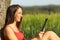 Girl reading an ebook or tablet in a green field