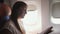 Girl reads book sitting on plane passenger seat closeup