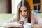 Girl reads messages on the phone while sitting in a cafe