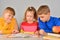 The girl reads stories from the book to her younger brothers, and they listen carefully