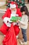 Girl Receiving Present Against Christmas Tree