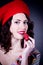 Girl in red beret eating strawberry.