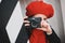 a girl in a red beret takes pictures on a city street