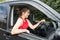 Girl in red clothes smiling while driving a car