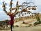 Girl in red coat stand under the Cappadocia famous Pottery tree