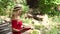 Girl in red dress reading a book sitting on bench.