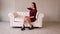 Girl in red dress sitting on a white leather couch.Full hd video