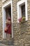 Girl in red dress taking picture in village of Ainsa, Spain