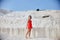 Girl in red dress on white travertines, Pamukkale