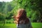 Girl with red hair blowing in the wind breathing deeply and looking away  with a blurred nature background. Soft focused