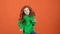 Girl red hair celebrating saint patrick`s day orange background moving cheerful