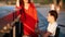 Girl With Red Hair And Guy On A Wheelchair Talking On The Waterfront On A Summer Evening