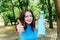 A girl with red hair rejoices and holds water in.glass bottle.