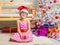 Girl in the red hat and the funny round glasses on a rug in a Christmas setting
