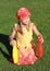 Girl in red hat kneeing with two bowls