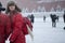 girl in a red jacket walking on Red Square in heavy snow