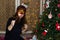 Girl in a red mask near a Christmas tree with sparkler.