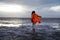 A girl in a red raincoat runs across a snowy field in the rain. Wild untouched nature of Iceland in winter. Travel