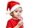 girl in red santa hat holds Christmas candy cane in hands. child eats lollipop with appetite, pleasure. holiday concept