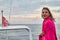 Girl in red scarf resting on a boat on water of sea or ocean in the evening