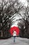 Girl with red umbrella walking in park in fall