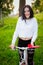 Girl on a red and white bike. A pretty young sexy tanned athletic girl rides in nature. cheerful and smiling brunette. good