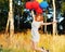 Girl redhead jumping with ballons at the yellow spikelets
