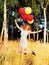 Girl redhead jumping with ballons at the yellow spikelets