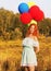 Girl redhead standing with ballons at the yellow spikelets