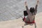 Girl rejoices in winning having raised her hands up sitting on steps in front of laptop. Technology, education and remote working