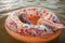 Girl relaxes on big donut inflatable ring on lake on hot summer day, happy summertime, countryside