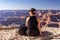 The girl relaxes on the edge of a rock overlooking the Grand Canyon in the USA and admires the view