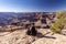 The girl relaxes on the edge of a rock overlooking the Grand Canyon in the USA and admires the view